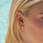 Gold Oval Huggies on model showing fit on ear