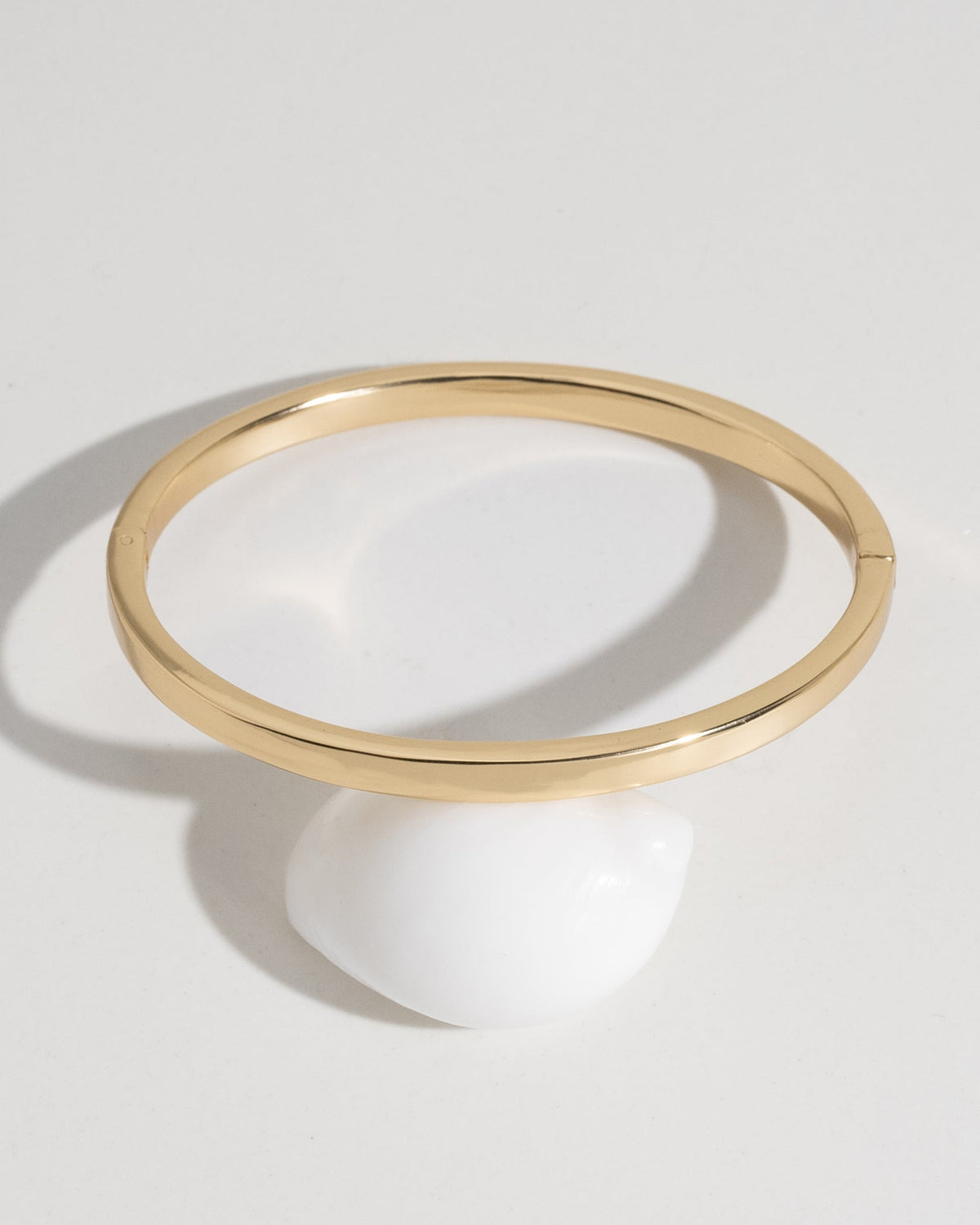 Classic gold bangle bracelet lifestyle product photo on surface