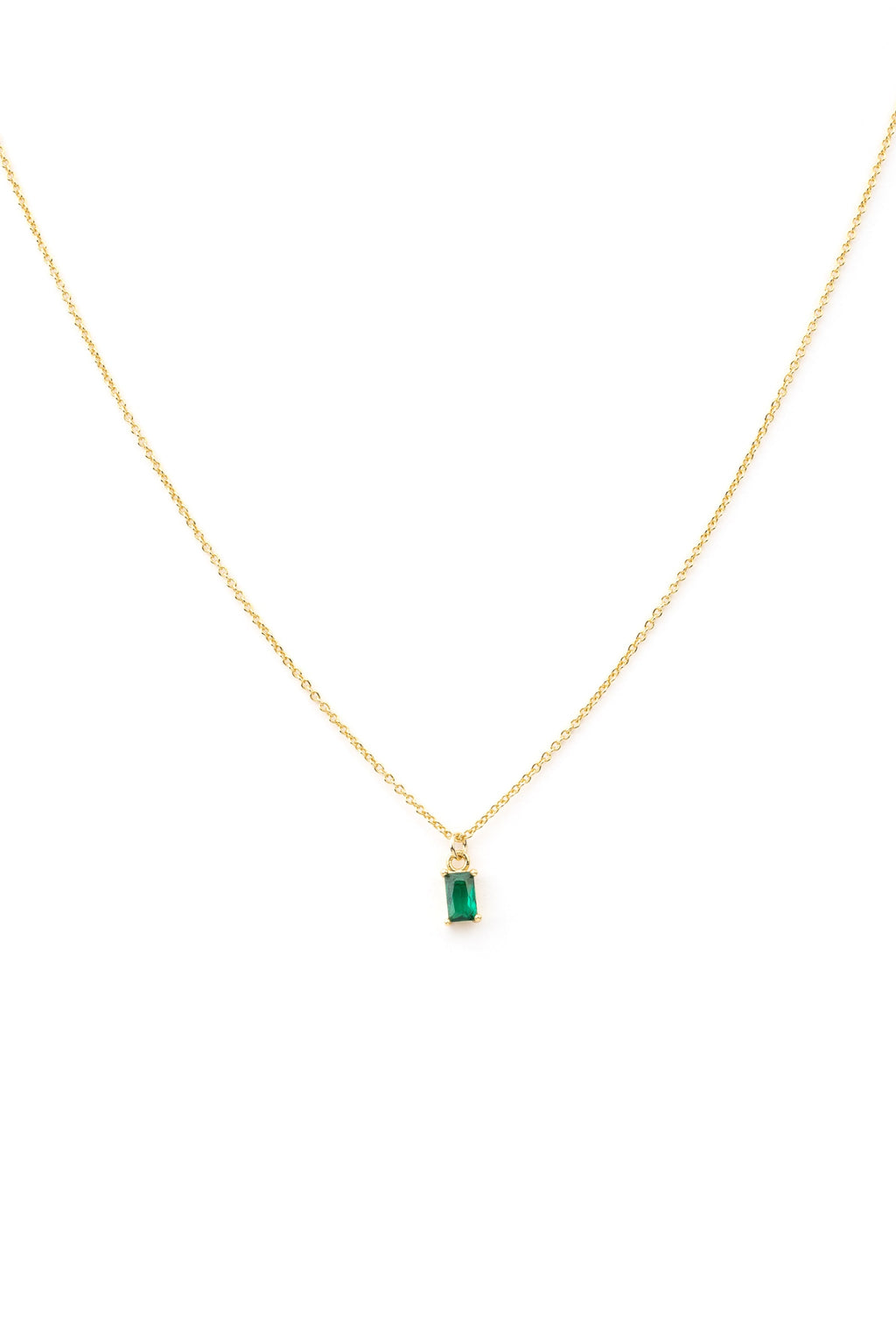 The Kismet Necklace features a gold-plated chain with a small rectangular emerald-green charm, shown on a white background.