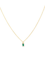 The Kismet Necklace features a gold-plated chain with a small rectangular emerald-green charm, shown on a white background.