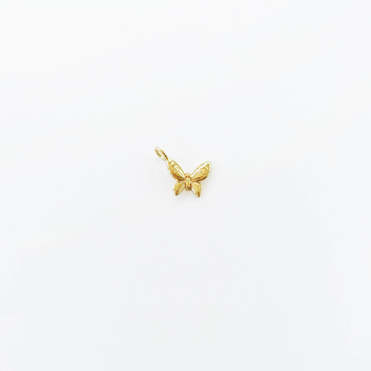 A delicate gold butterfly charm from LLUME Jewelry's Build a Charm Necklace collection is displayed on a plain white background—ideal for creating your own necklace or expanding your gold filled charm assortment.