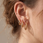 Three Classic Round gold hoops in graduated sizes stacked along the earlobe