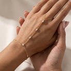Woman wearing the Amélie gold hand chain with marquise crystals from wrist to finger loop