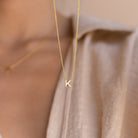 Dainty Initial Necklace featuring a gold letter K pendant, styled over a beige shirt with a blurred background—an ideal customizable accessory and thoughtful Christmas gift.