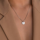 A close-up of the Mini Initial Tag Necklace with N, S, and B letter pendants, paired with a tan blazer—an elegant personalized accessory and an ideal Christmas gift.