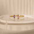 The Duo Marquise Baguette Ring showcases a purple marquise and a pink baguette stone on a translucent band. Experience the allure of handcrafted jewelry with this personalized gemstone ring.