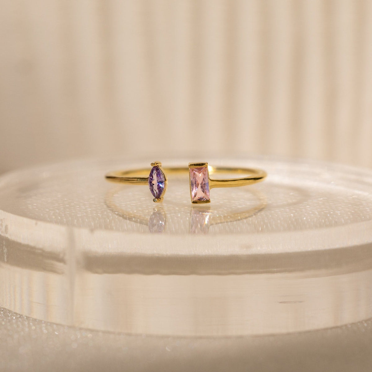 The Duo Marquise Baguette Ring showcases a purple marquise and a pink baguette stone on a translucent band. Experience the allure of handcrafted jewelry with this personalized gemstone ring.