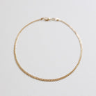The Marie Chain by LLUME Jewelry is a delicate, thin gold bracelet with a small clasp, shown in a circle on a white background. Perfectly pairs with any 18k gold-filled necklace for an elegant, coordinated style.
