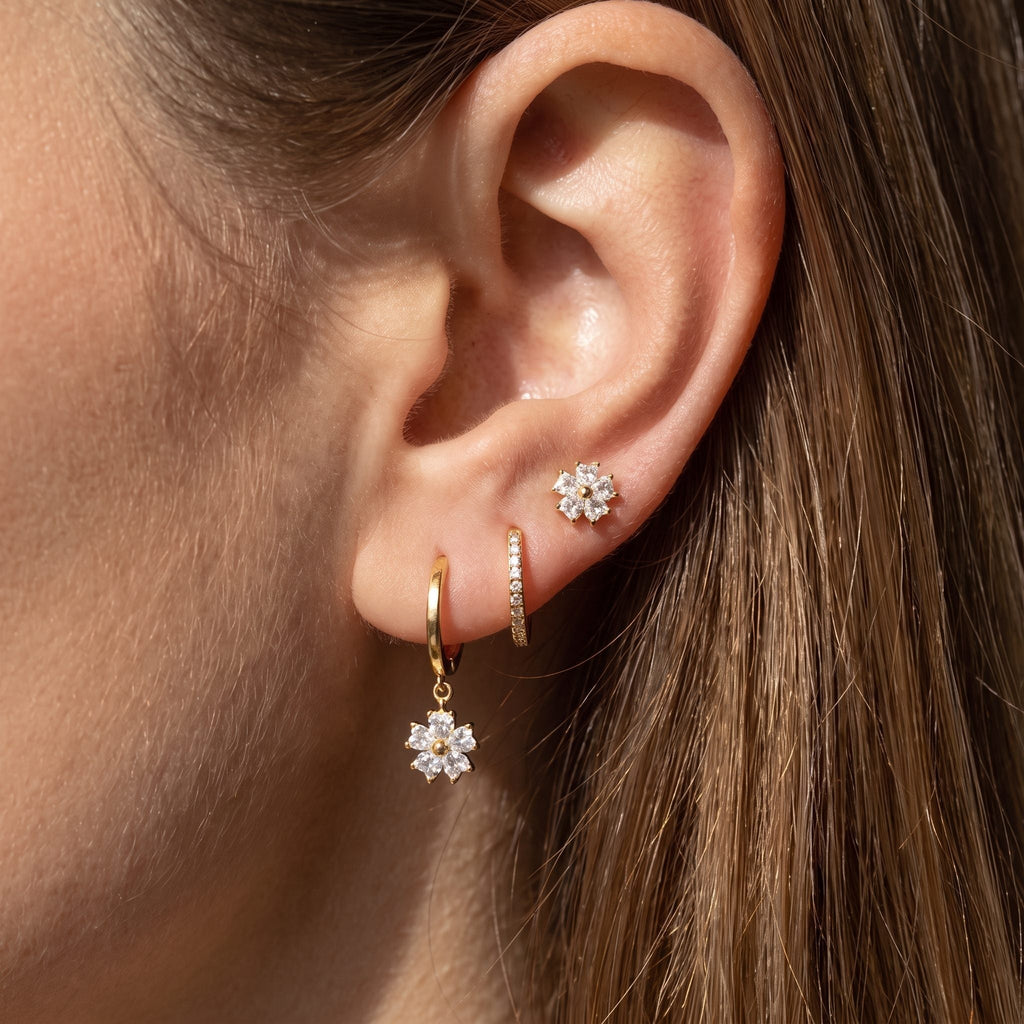 Ear styled with the Lilou gold set: crystal flower stud, pavé huggie and flower charm hoop