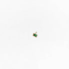 The LLUME Jewelry Build a Birthstone Necklace, featuring a small rectangular gold pendant with a green gemstone, is displayed in the center of a plain white background.