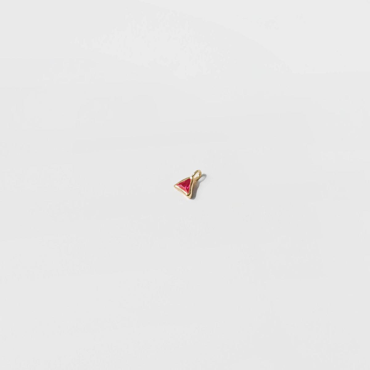 The LLUME Jewelry Build a Birthstone Necklace features a small gold-plated charm pendant with a red triangular center, displayed on a plain white background.