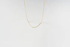 The Adelene Paperclip Chain by LLUME Jewelry features delicate gold-plated oval links, elegantly displayed against a plain white background.