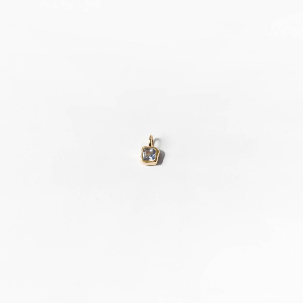 The Build a Birthstone Necklace by LLUME Jewelry features a small gold square pendant with a light gemstone, shown against a plain white background.