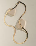 Wavy, swirl-shaped gold jewelry piece