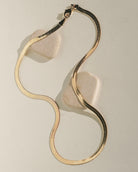 Wavy, swirl-shaped gold jewelry piece