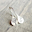 Sterling silver teardrop dangle earrings with dandelion motif, hook closure.