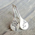 Sterling silver teardrop dangle earrings with dandelion design and hook closure.